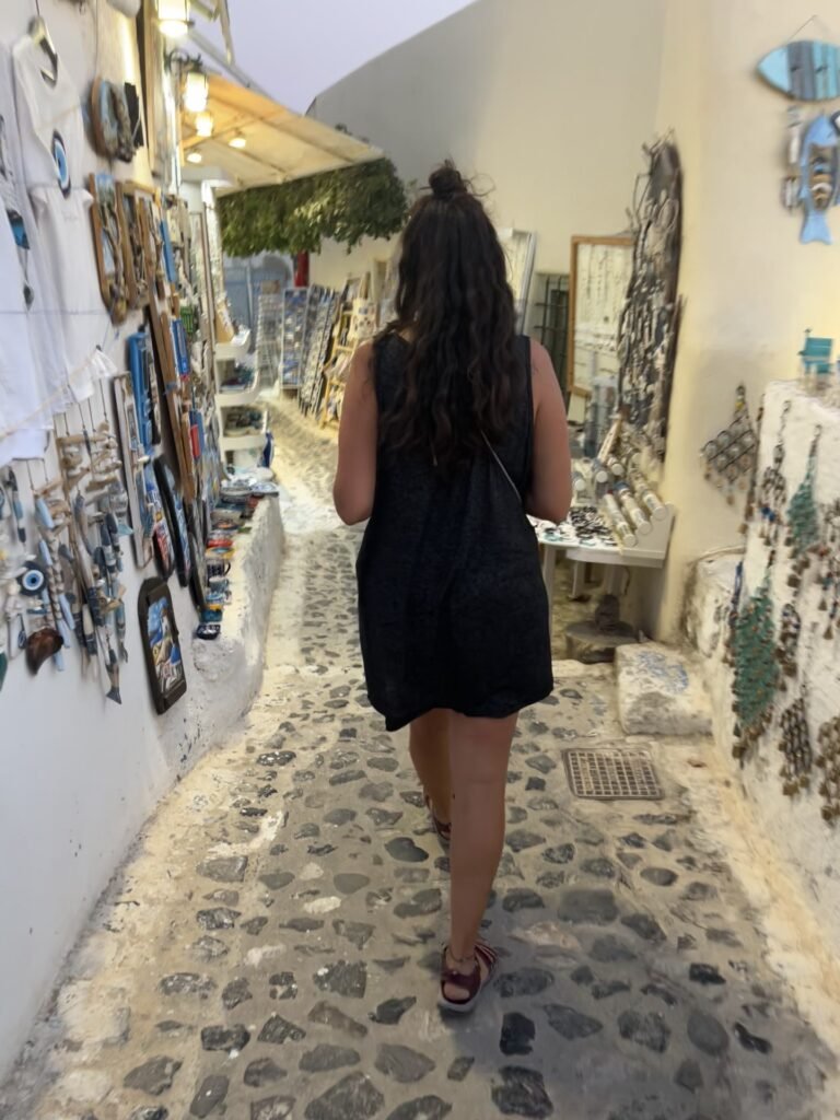 donna che passeggia per i negozi di fira la sera, santorini