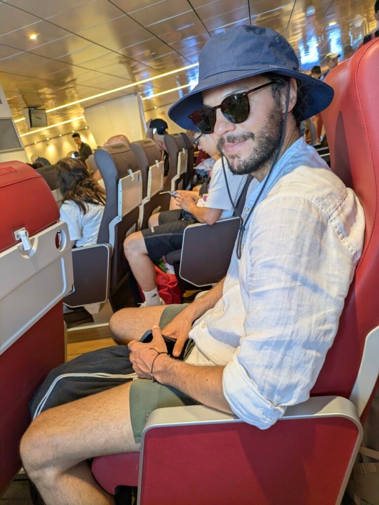 uomo su sedile nel traghetto da santorini a milos